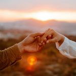 Couple holding hands and looking at each other with hope, representing healing and rebuilding trust after infidelity