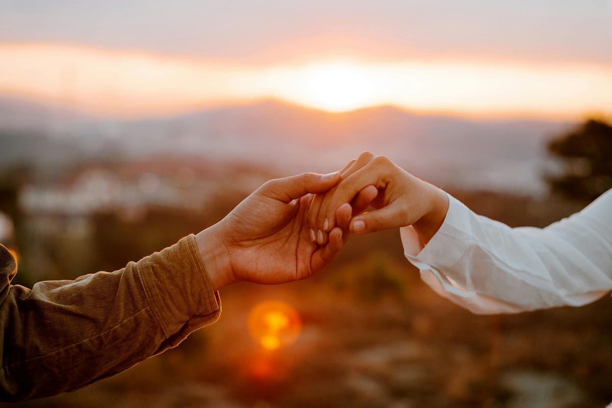 Couple holding hands and looking at each other with hope, representing healing and rebuilding trust after infidelity