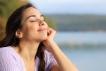 woman sitting calmly with closed eyes, practicing relaxation