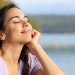 woman sitting calmly with closed eyes, practicing relaxation