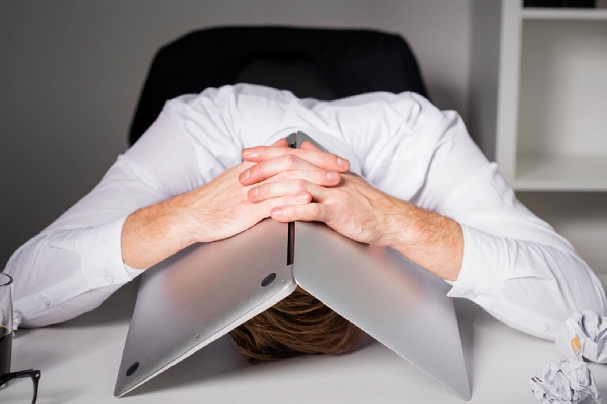 person surrounded by unfinished tasks, looking overwhelmed