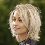 Professional hair colorist working on a client's hair with modern coloring techniques, representing hair color trends