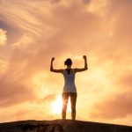 person standing tall with arms raised, symbolizing regained confidence