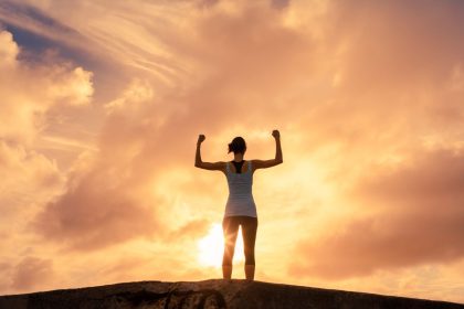 person standing tall with arms raised, symbolizing regained confidence