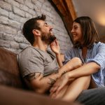 couple sitting apart on a couch looking frustrated, illustrating relationship strain