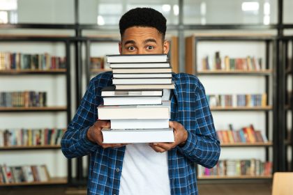 stack of inspiring books with a person reading thoughtfully
