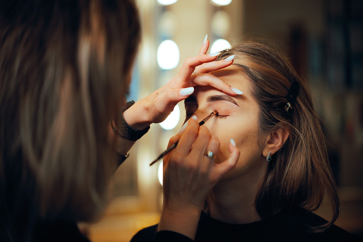 Professional makeup artist demonstrating eye makeup application on different eye shapes, representing personalized eye makeup techniques